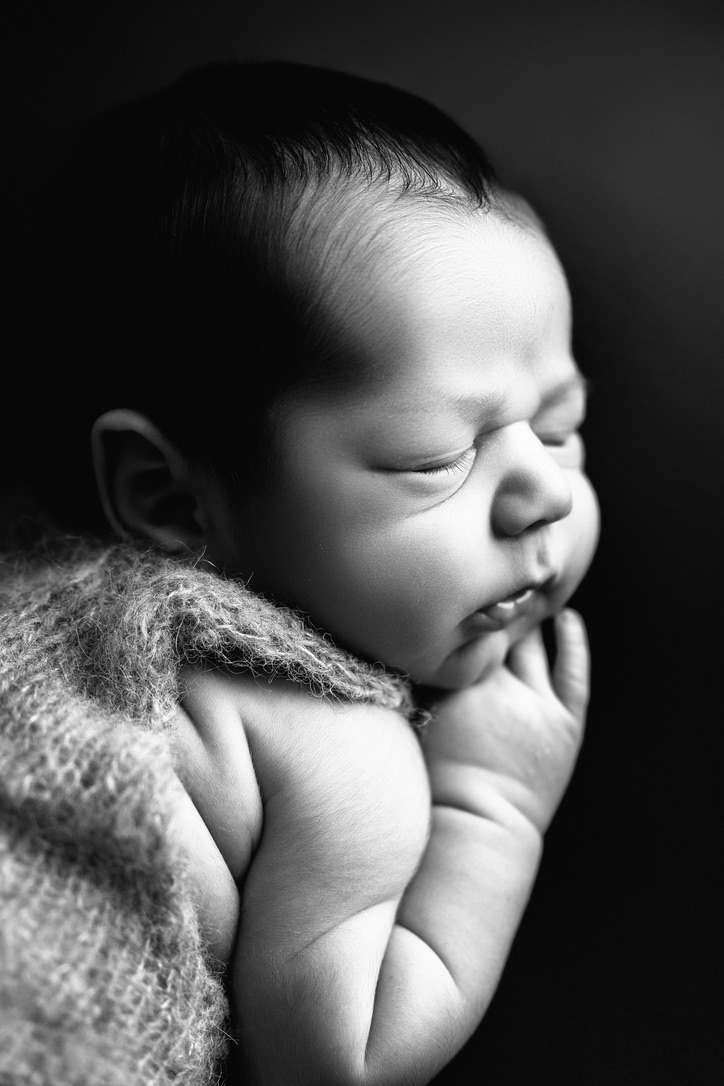 Sleeping newborn baby in black and white studio portrait by Fresno newborn photographer