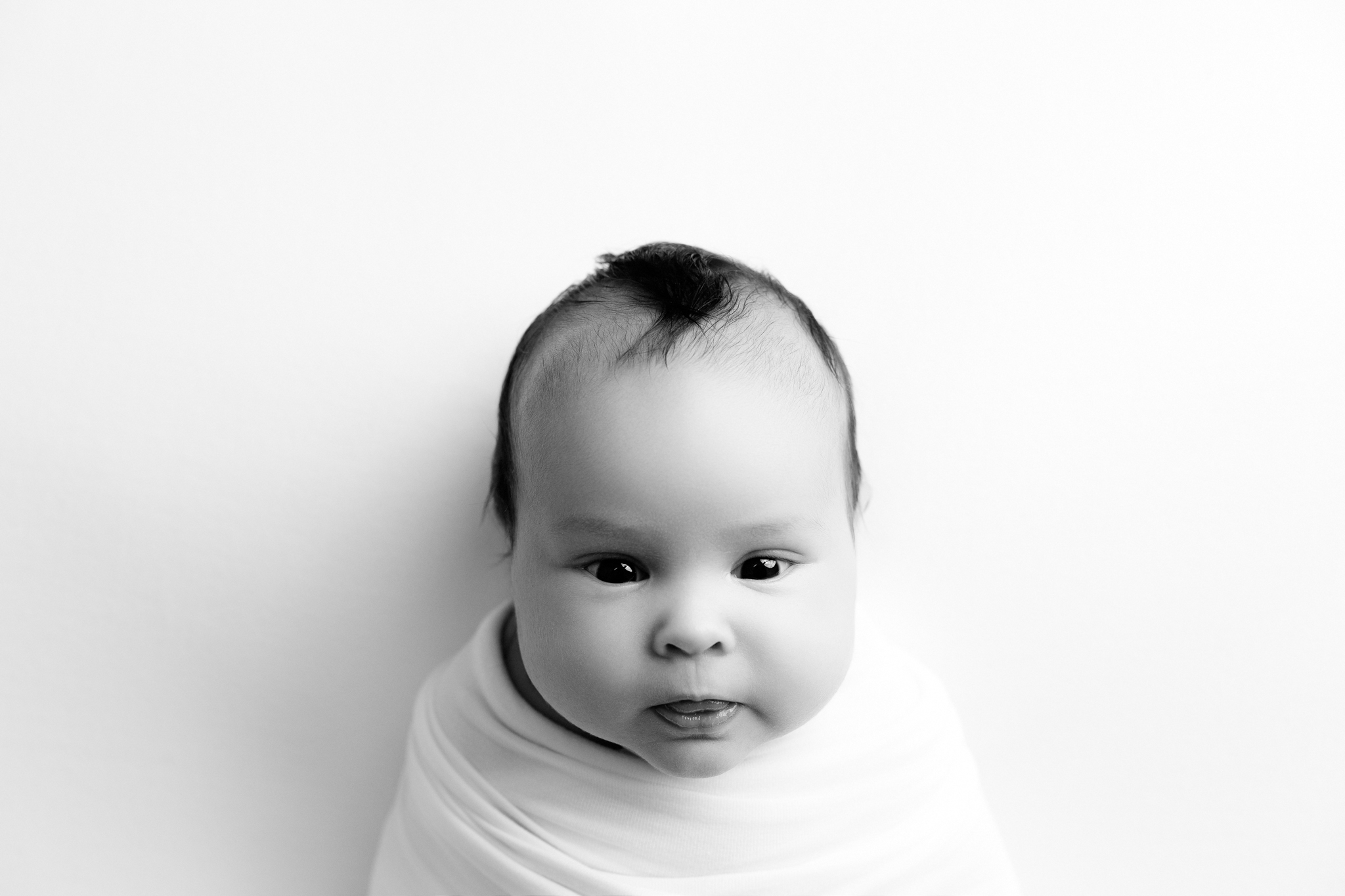 Fresno newborn photographer capturing a wrapped baby in a studio portrait