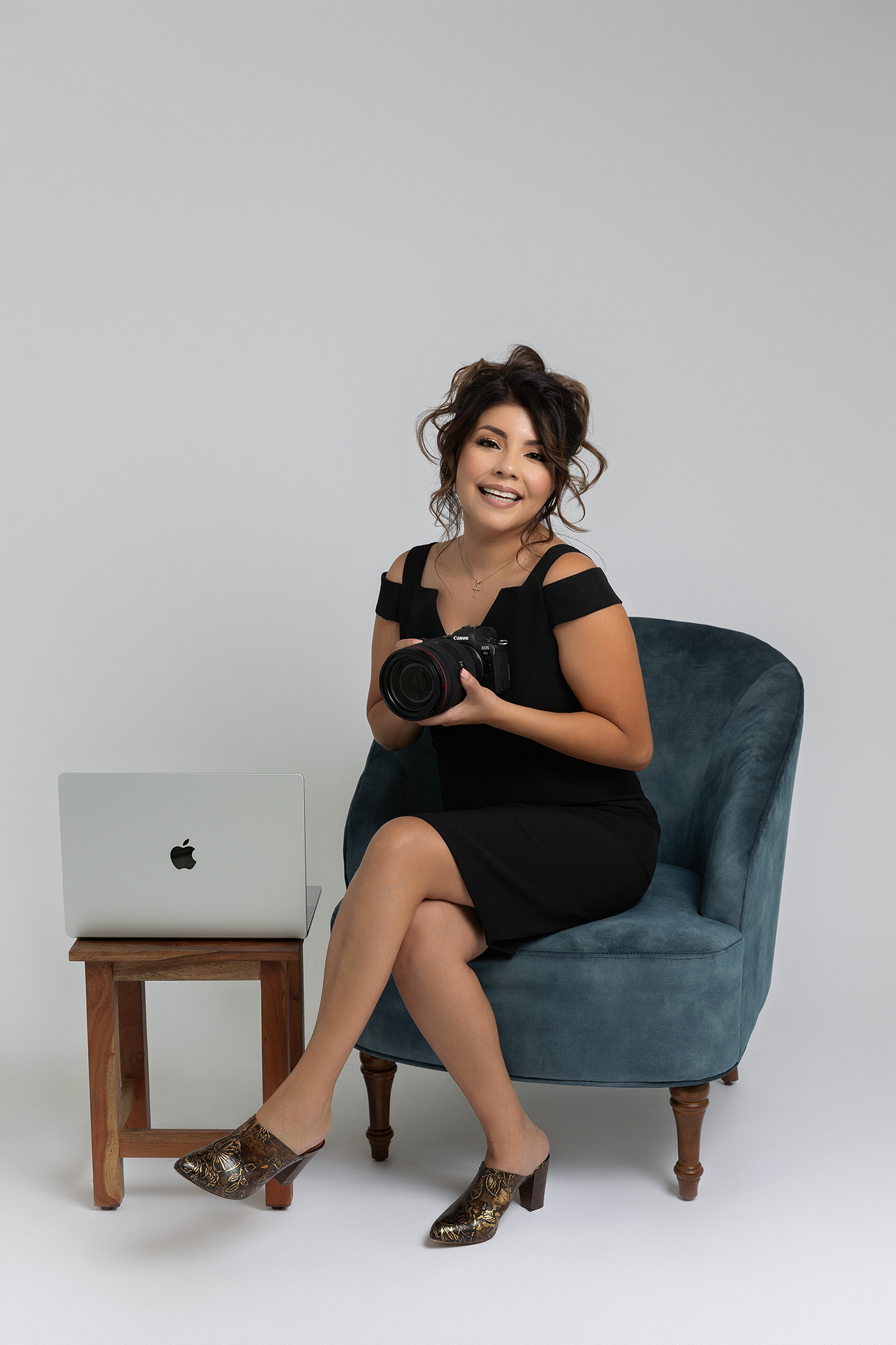 Central Valley maternity photographer Stephanie Leal holding her camera during a Fresno studio session