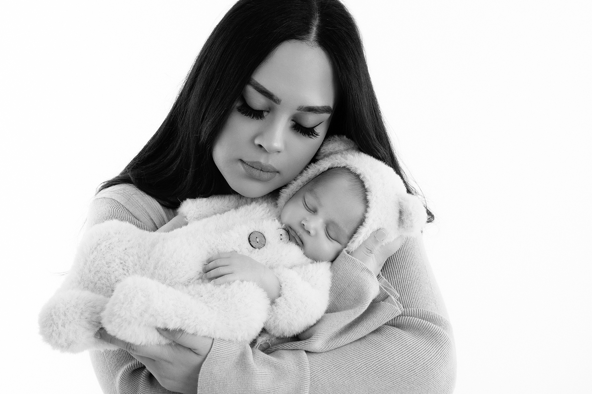 Mother gently holding her newborn baby in black and white portrait by Fresno California newborn photographer Stephanie Leal