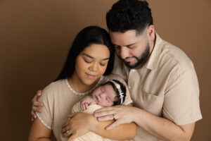 Mother and father holding their newborn baby during a studio newborn photography session in Fresno, California
